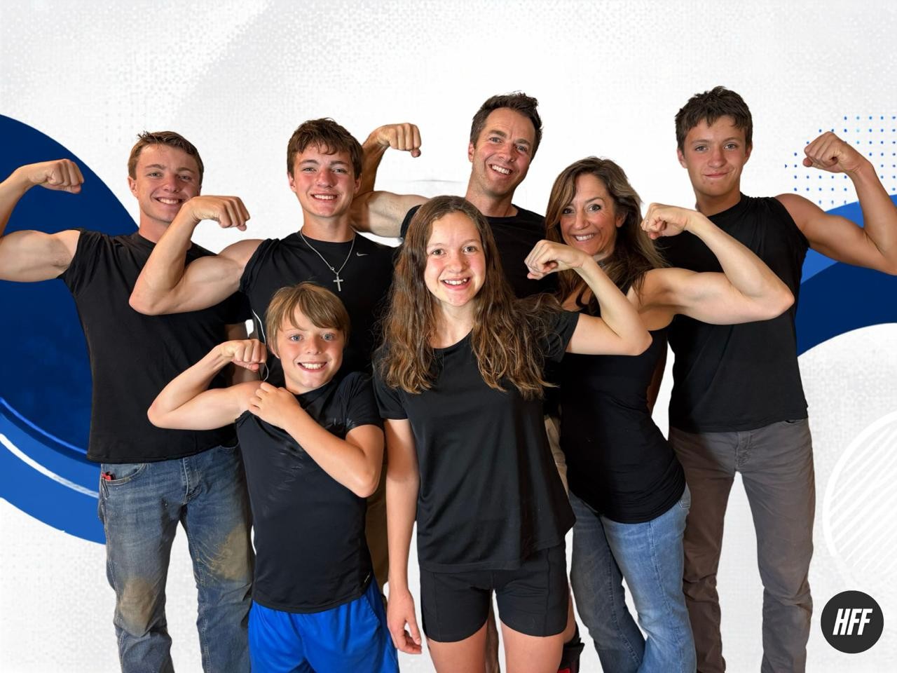Coach Jenn with her husband and five kids, all flexing their arms and smiling.